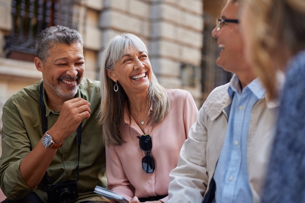 A group of older adults laugh together, illustrating the "2030 problem" of Baby Boomers aging without enough younger people to care for them.