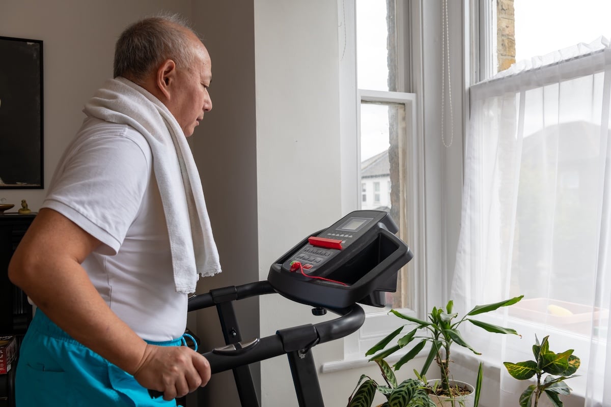 An older man exercises on the treadmill at home, demonstrating the importance of starting an exercise routine after 60.