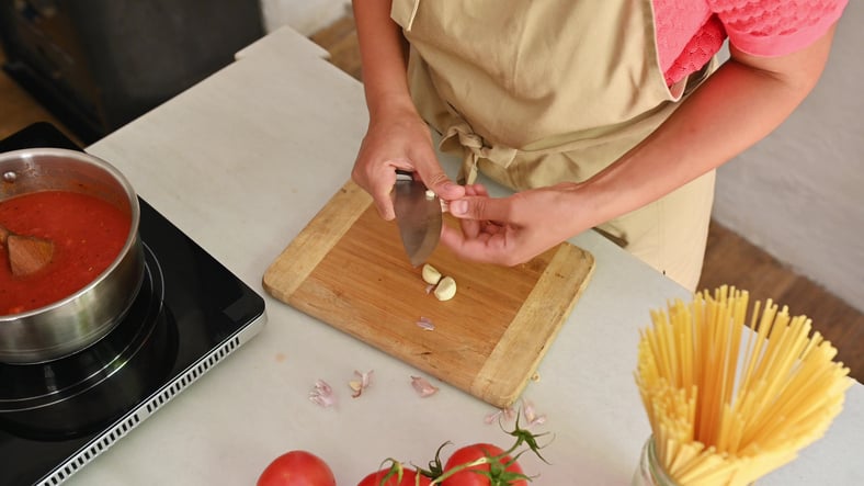 Senior cooking for one with pasta and garlic