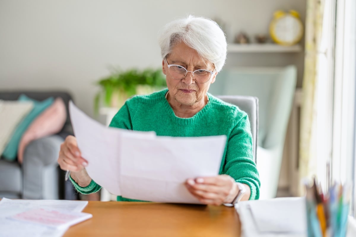 An older woman looks over paperwork to designate a medical power of attorney.