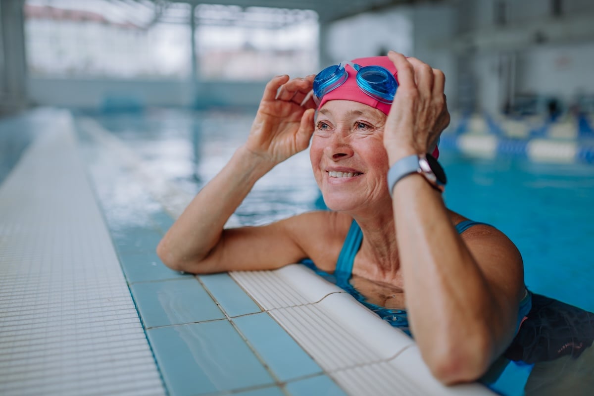 An older woman stopping for a break while swimming laps, demonstrating one of the four pillars of the new retirement.