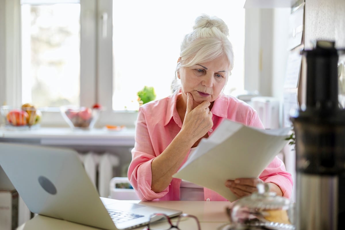 A woman looks over legal documents, illustrating the importance of estate planning for solo agers.